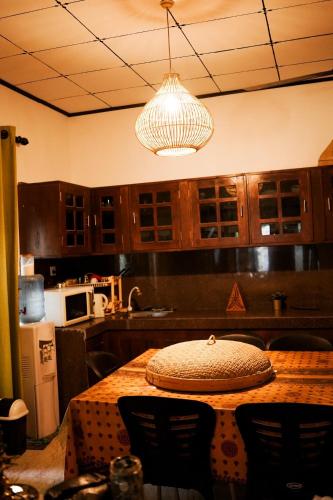 a kitchen with a wooden table and a light fixture at Ocean Life Ayurvedic Villa in Talalla South