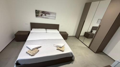 a bedroom with a bed with towels and a mirror at Le Case di Stela in Terni