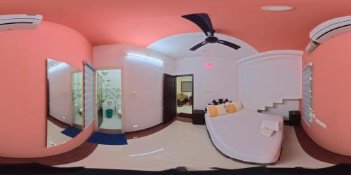 a bathroom with pink walls and a large mirror at J V A Home stay Apartment Hotel in Kollam