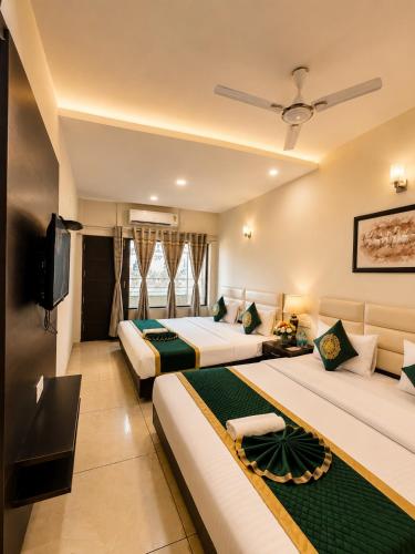 a hotel room with two beds and a flat screen tv at Hotel Woodlark Heights Zirakpur Chandigarh !! Family Hotel ! Easy Airport Access ! Budget Friendly in Chandīgarh