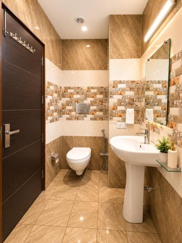 a bathroom with a toilet and a sink at Hotel Woodlark Heights Zirakpur Chandigarh !! Family Hotel ! Easy Airport Access ! Budget Friendly in Chandīgarh
