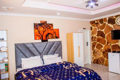 a bedroom with a bed and a rock wall at 7Palms Executive Lodges in Ndola