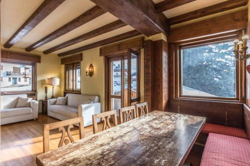 a living room with a wooden table and chairs at Cantore, Cortina by Short Holidays in Cortina dʼAmpezzo