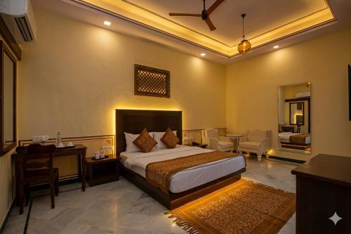 a bedroom with a bed and a desk and a room at Aaram Baagh Maheshwar in Maheshwar