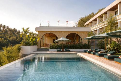 a swimming pool in front of a building at Kanalla Boutique Hotel - Adults Only in Kuta Lombok