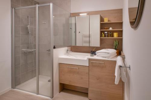 a bathroom with a sink and a shower at DOMITYS - Les Quernons in Trélazé