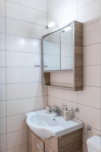 a bathroom with a sink and a mirror at Corfu Dream Holidays Villas in Glyfada
