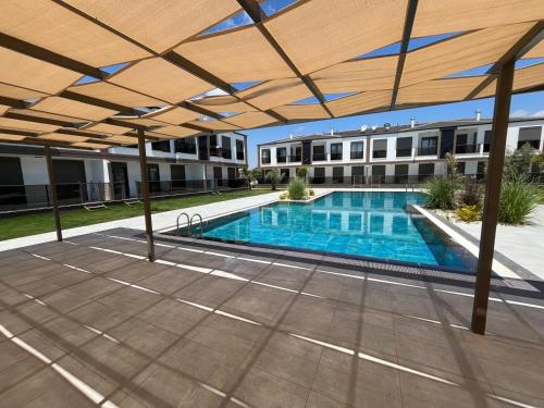 an overhead view of a swimming pool with a wooden pergola at Liza Evren Sitesi in Manavgat