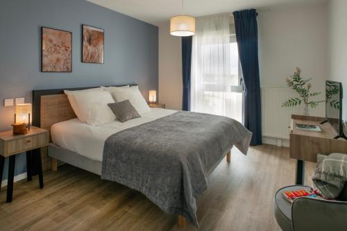 a bedroom with a large bed and a window at DOMITYS - Les Quernons in Trélazé