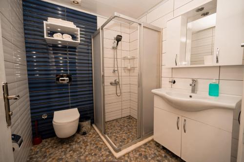 a bathroom with a shower and a toilet and a sink at Loca Centre Suites in Bodrum City