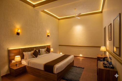 a hotel room with a bed and two lamps at The Vanashva in Tehla