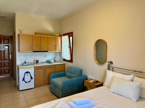 a bedroom with a bed and a chair and a kitchen at Artion Studios in Vourvourou