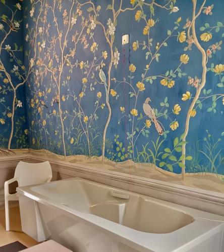a bathroom with a bath tub and a blue wall at Kurzentrum Ludwigstorff GmbH in Deutsch Altenburg