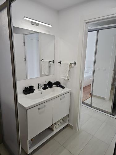 a white bathroom with a sink and a mirror at Blue Sea OLIMP by Any - Etaj PREMIUM cu vedere la Mare in Olimp