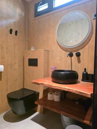 a bathroom with a black toilet and a mirror at Villa Beach Charly in Tisno