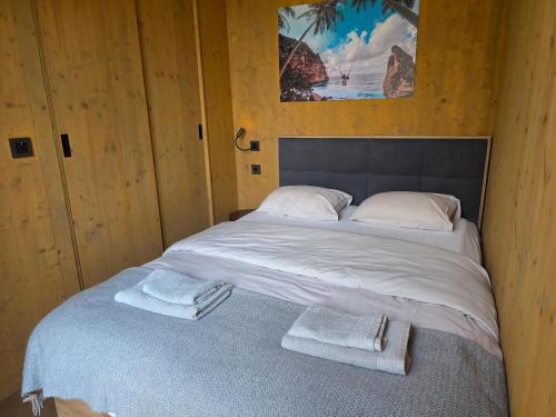 a bed in a wooden room with towels on it at Villa Beach Charly in Tisno
