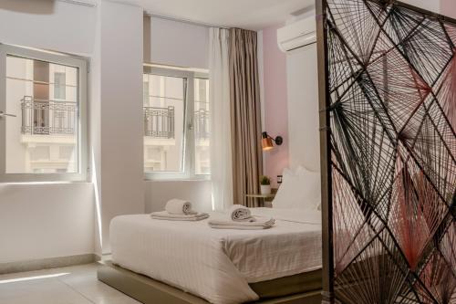 a bedroom with a bed with two towels on it at Rooster Suites in Athens