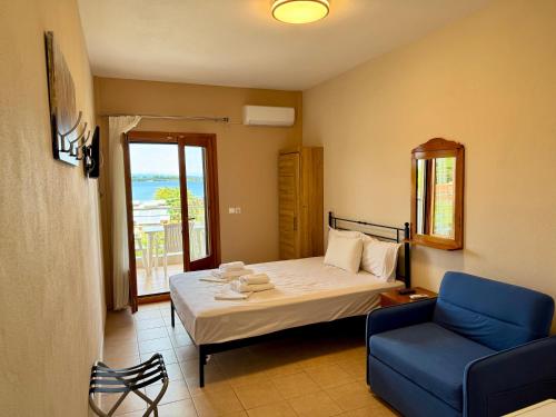 a bedroom with a bed and a blue chair at Artion Studios in Vourvourou