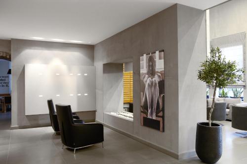 a lobby with black chairs and a painting on the wall at Aegli Hotel Volos in Volos