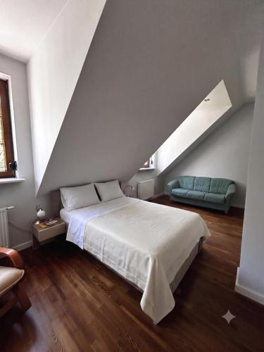 a bedroom with a white bed and a blue couch at Dwór Grabina in Ciechomice