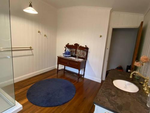 a bathroom with a sink and a mirror at Awen Cottage in Tenterfield