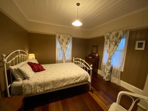 a bedroom with a white bed and a window at Awen Cottage in Tenterfield