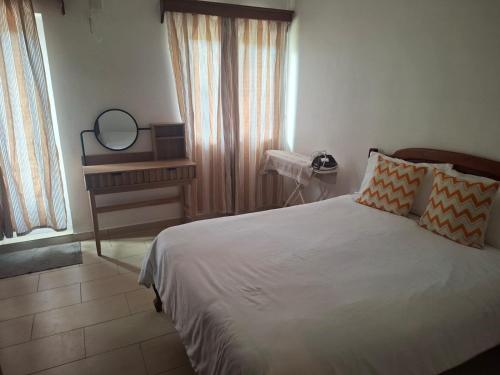 a bedroom with a bed with a mirror and a window at Blue bay in Blue Bay