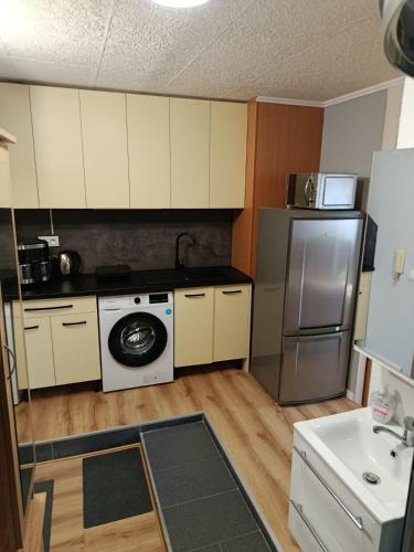 a small kitchen with a refrigerator and a washer at Apartmán Comfort in Trenčín
