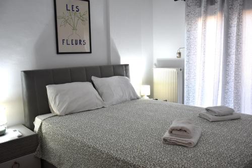 a bedroom with a bed with two towels on it at Sxoleio Apartment in Kamariotissa