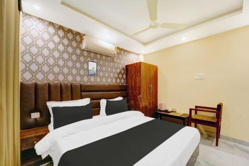 a bedroom with a black and white bed and a chair at Super Hotel O The Dev Regency in Patna