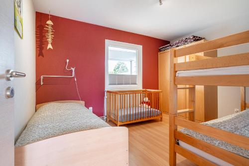a bedroom with two bunk beds and a crib at Bungalow Windsbraut in Norddeich