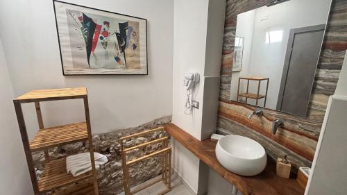 ein Badezimmer mit weißer Toilette und Spiegel in der Unterkunft Yllen Rooms in Avola