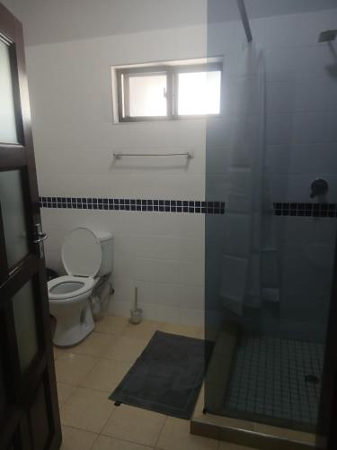 a bathroom with a toilet and a window at GreenLand Hotel in Kasane