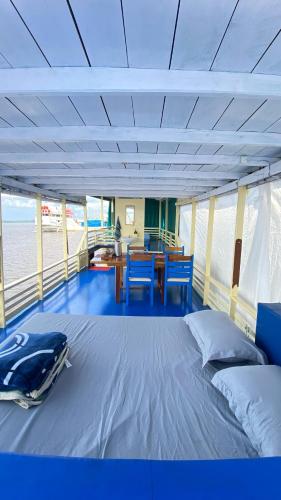 a room with a bed and a table on a boat at Kelotok Orangutan Tanjung Puting in Kumai