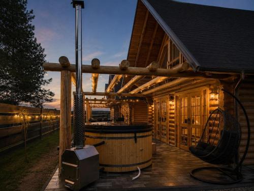 a wooden cabin with a hot tub on a deck at Balujemy w Radawie in Radawa