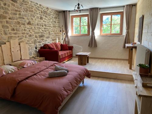 a bedroom with a bed and a brick wall at Du Baume Au Cœur in Baume-les-Messieurs