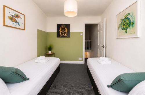 two beds in a room with green and white walls at York House - Garston - 3 bedroom - Sleeps 6 in Liverpool