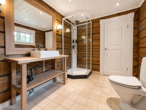 a bathroom with a toilet and a sink and a shower at Dream mountain cabin with jacuzzi and views in Gol