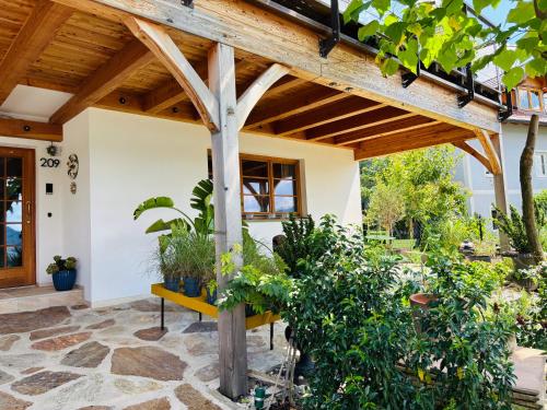 an outdoor patio with a wooden pergola and plants at See Apartment Traunsteinstrasse in Gmunden