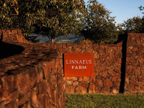 a sign that reads interns farm on a stone wall at Linnaeus Farm, Berry - by Linnaeus Collection in Berry