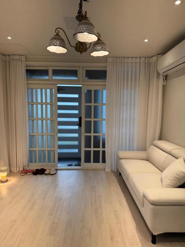 a living room with a white couch and windows at 차북차북 in Kwakchi-ri