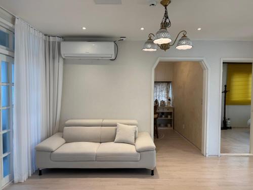 a living room with a white couch and a hallway at 차북차북 in Kwakchi-ri