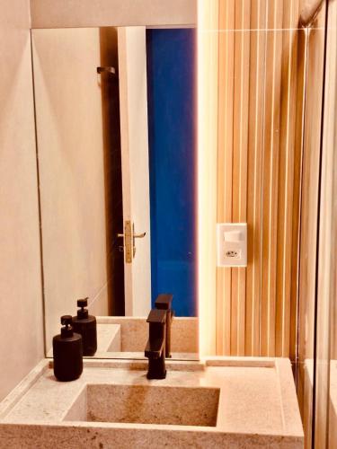 a bathroom with a sink and a mirror at Desing Studio, luxo e Moderno Vila Velha-ES in Vila Velha