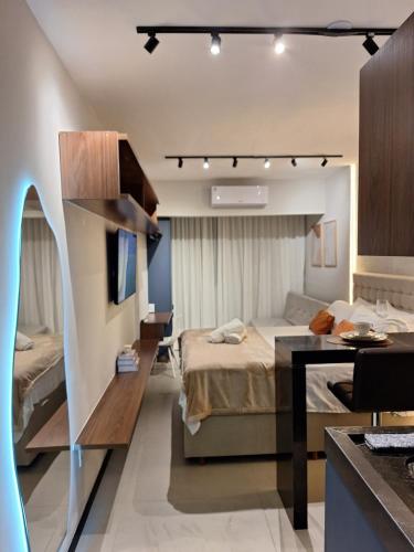 a bedroom with a bed and a desk in a room at Desing Studio, luxo e Moderno Vila Velha-ES in Vila Velha