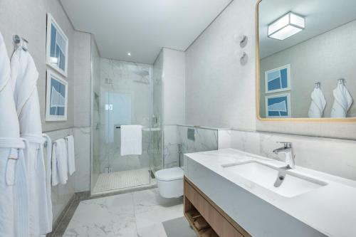 a bathroom with a sink and a shower and a toilet at Palace Beach Resort in El Alamein