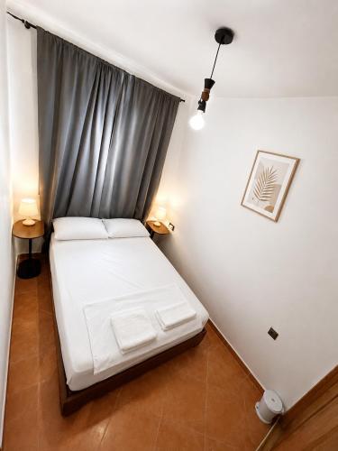 a small bedroom with a white bed and a window at Andalucia Cabo in Cabo Negro