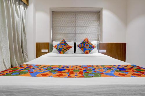 a bedroom with a bed with a colorful bedspread at FabHotel Vaishnav Bairagi in Nashik