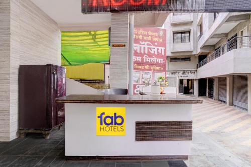 a restaurant with a counter in a building at FabHotel Vaishnav Bairagi in Nashik
