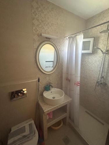a bathroom with a sink and a toilet and a mirror at House Stamatis in Sarti
