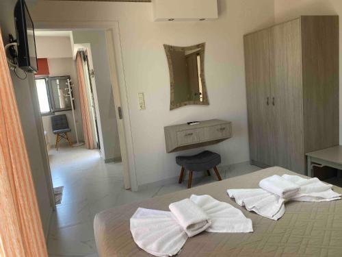 a bedroom with a bed with white towels on it at Sirena Apartments in Agia Pelagia